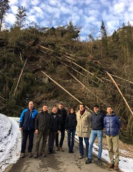 I consiglieri con alle spalle il bosco raso al suolo