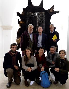 Foto di gruppo con alle spalle una delle opere in mostra